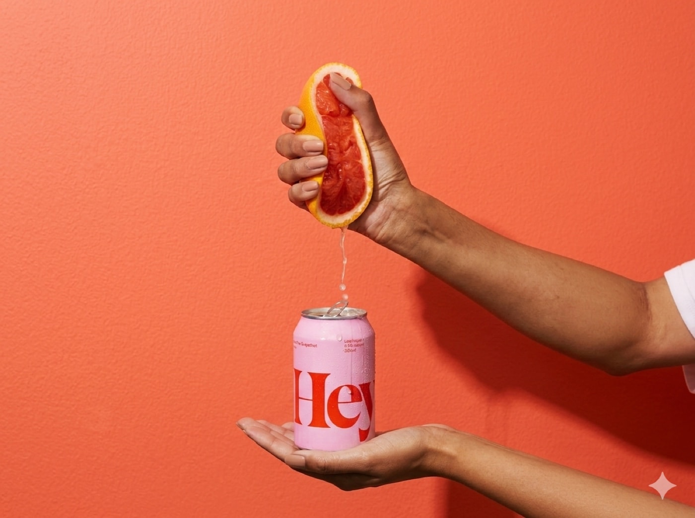 Hand knijpt grapefruit uit boven een blikje